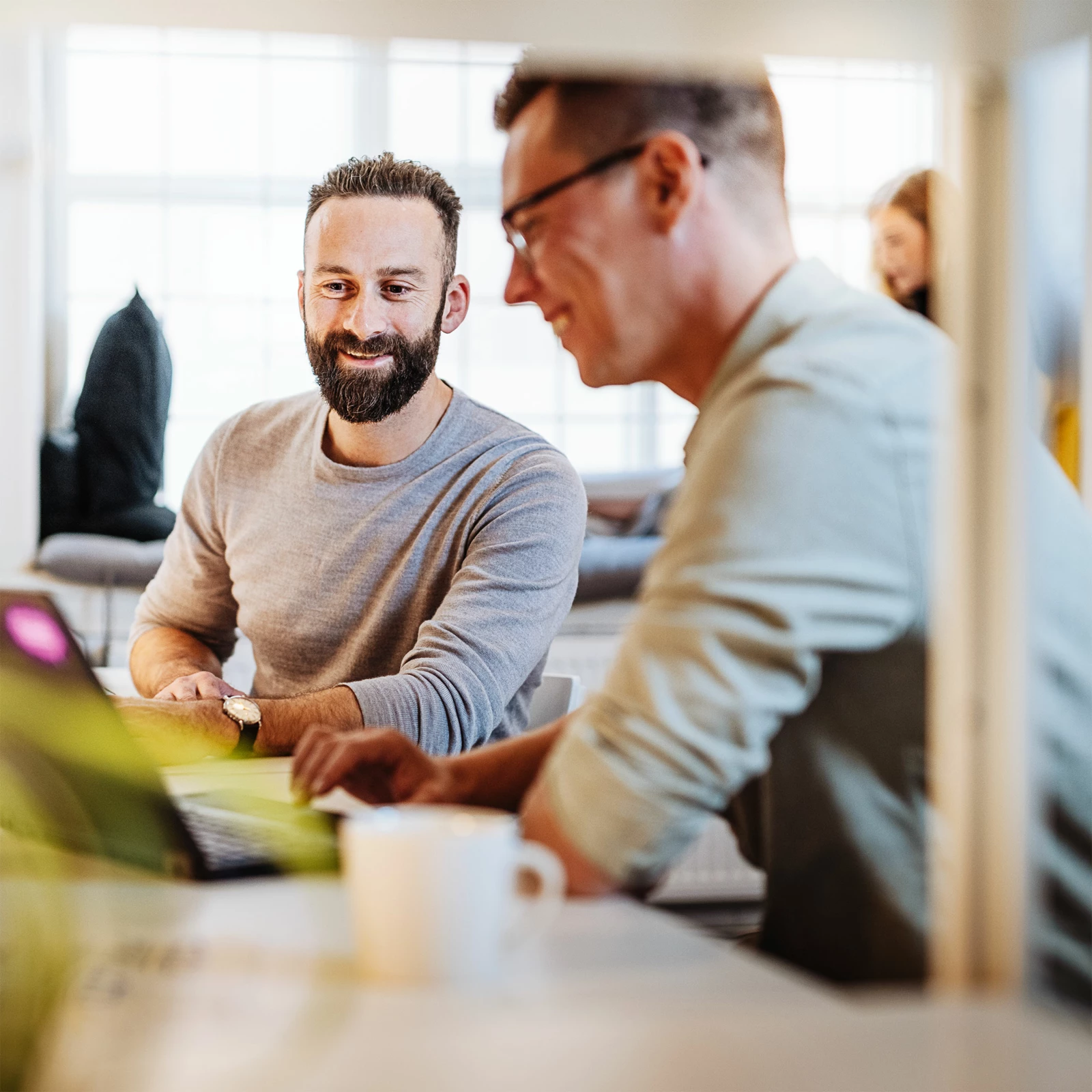 Teammeeting mit Laptop und Kaffeetasse